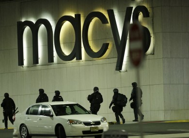 Officials wearing tactical gear walk outside of Garden State Plaza Mall.