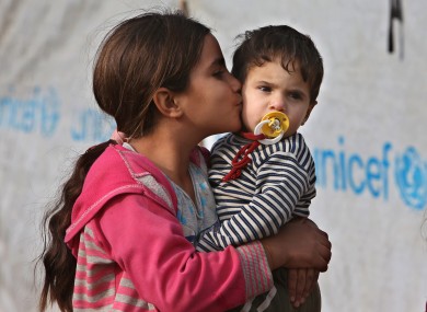 A Syrian displaced girl kisses her younger brother at one of the Syrian refugee camps at Delhamiyeh village in the Bekaa valley in Lebanon.