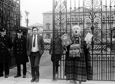 Bertie Ahern, then Chief Whip of Fianna Fáil outside Leinster House, as former school teacher Margaret dances in honour of the Holy Trinity and Virgin Mary.