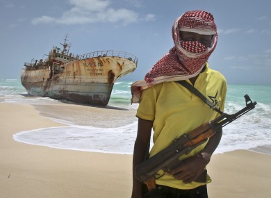 Masked Somali pirate 'Hassan' stands near a Taiwanese fishing vessel in this September 2012 file photo
