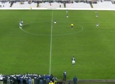 The players of Racing Santander stand motionless in the centre circle.
