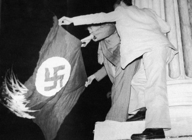 At the Municipal Theater in Rio De Janeiro, Brazil August 20, 1942 two Brazilians hold a Nazi flag which they have set fire to during a protest.