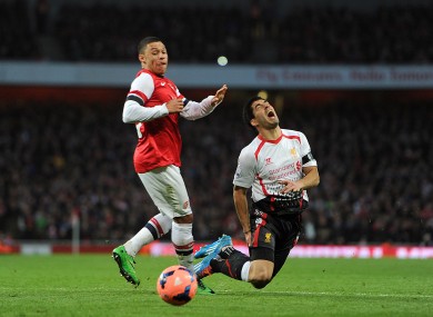 Liverpool's Luis Suarez goes to ground after a challenge from Arsenal's Alex Oxlade-Chamberlain.