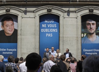 Florence Aubenas, holding a microphone at center, a French journalist who was held hostage in Iraq, delivers her speech during a gathering for Europe-1 radio reporter Didier Francois and independent photographer Edouard Elias.