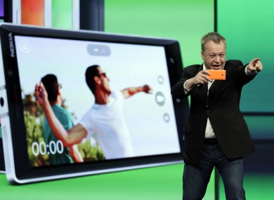Stepen Elop, executive vice president of Nokia, demonstrates the picture taking ability of the new Nokia Lumia 930 phone during a keynote address of the Microsoft Build Conference.