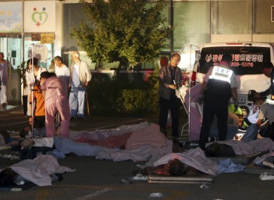 Rescued patients are placed on the ground outside the hospital.