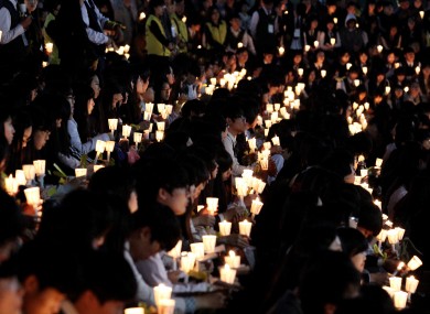 High school students hold candles during a rally to pay tribute to the victims and missing passengers of the sunken ferry Sewol in Ansan.