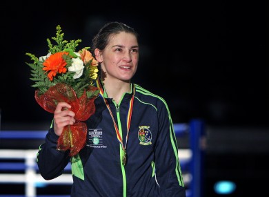 Katie Taylor with her latest gold medal and a charming bunch of flowers.