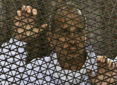 In this file photo taken Wednesday, March 5, 2014, Al Jazeera journalist Peter Greste stands inside the defendants' cage in a courtroom during a trial on terror charges, along with several other defendants, in Cairo Egypt.
