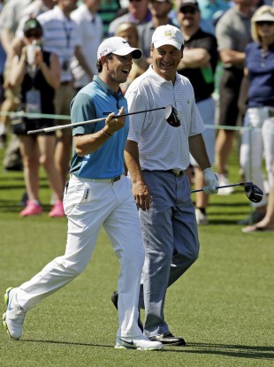 Rory McIlroy walks with Jeff Knox down the eighth fairway at Augusta last year.