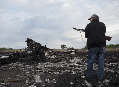 A pro-Russia fighter stands on guard the crash site of a Malaysia Airlines jet.