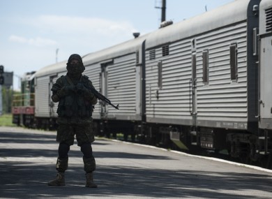 A pro-Russia fighter guards the platform in Torez, eastern Ukraine, as the train bearing bodies of MH17 victims leaves the station.