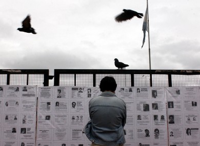 A man looks at pictures of people who disappeared during the dictatorship in Argentina.