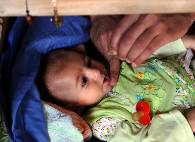 An Iraqi internally displaced Yazidi child receives a polio vaccine at the town of Khanke, outside Dahuk, 260 miles (430 kilometers) northwest of Baghdad.