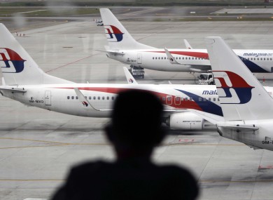 A man views a fleet of Malaysia Airline planes on the tarmac of the Kuala Lumpur International Airport.