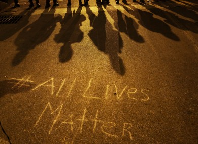 A message written on the pavement as police in riot gear cast shadows in Baltimore on 1 May.