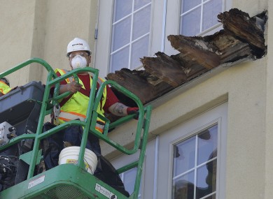 A crew works on the remaining wood of an apartment building balcony that collapsed in Berkeley.