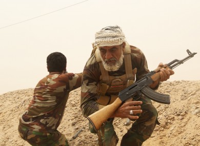 Fighters from the Badr Brigades Shiite militia clash with Islamic State group militants at the front line on the outskirts of Fallujah, Anbar province, Iraq.