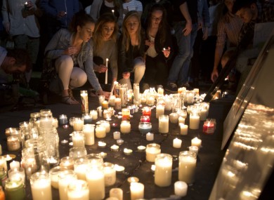 Mourners lay candles during a vigil in June.
