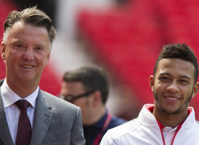 Manchester United's new player Memphis Depay, right, smiles as he walks alongside manager Louis van Gaal.