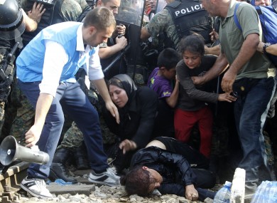 A migrant who has collapsed while the crowd of migrants were pushing the police to enter Macedonia .