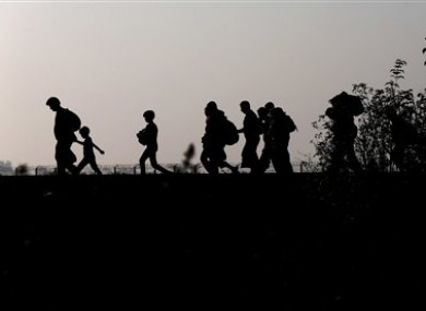 Migrants walk on the railway track after crossing the border line between Serbia and Hungary near Roszke, southern Hungary.