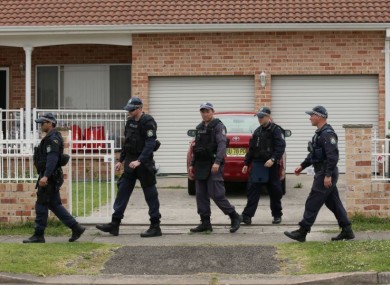 Police walk around a property in the suburb of Guildford in Sydney.
