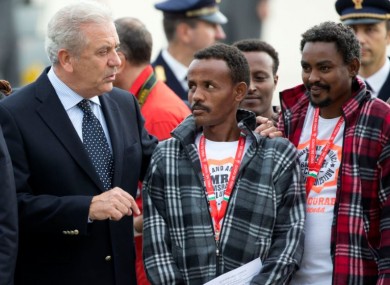European Commissioner for Migration and Home Affairs Dimitris Avramopoulos, left, speaks to Eritrean refugees waiting to board an Italian aircraft that will take them to Sweden, at Rome's Ciampino airport in October.