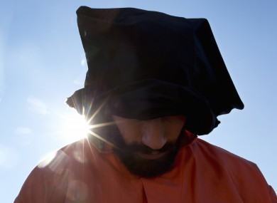 A protester wearing an orange jumpsuit depicting a Guantanamo Bay detainee, participates in a rally outside of the White House in Washington in January.