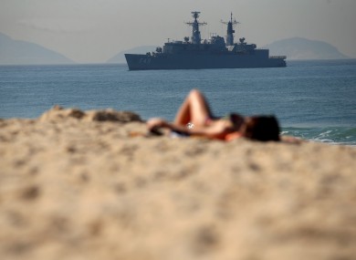 Sunbathers relax on the Copacabana beach as the Brazilian navy provides security at sea at the Olympic Games in Rio de Janeiro.
