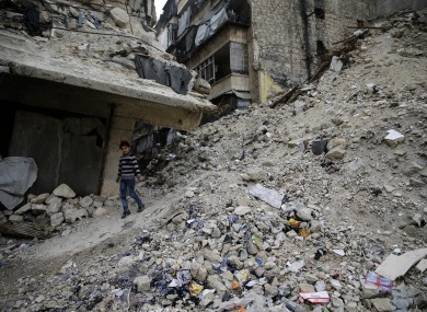 A Syrian girl walks amid the wreckage of damaged buildings and shops in the western city of Aleppo.