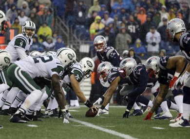 Players from the New York Jets and New England Patriots about to collide at the line of scrimmage.