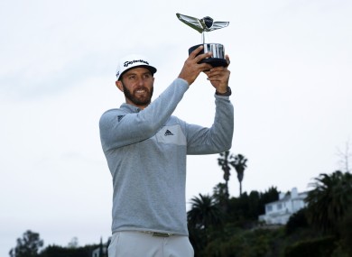Johnson posing with his trophy on the 18th green.