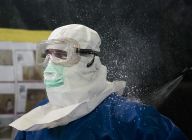 A volunteer of the German forces Bundeswehr gets sprayed a bleach mixture on his protective suit during a training for the Ebola virus in Appen.