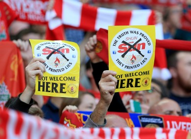 Liverpool fans hold up 'Shun the Sun, Not Welcome Here' fliers during a Premier League match at Anfield last September.