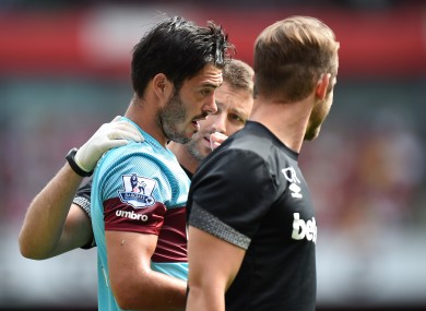 West Ham defender James Tomkins is helped off the pitch by medical staff after a clash of heads with Arsenal's Olivier Giroud.