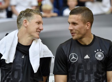 Payday: Podolski, right, with German team-mate Bastian Schweinsteiger of Manchester United.