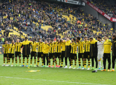 The Borussia Dortmund team stand before the jersey of Marc Bartra, injured in the attack.