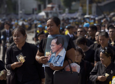 Thai mourners stand in a line to pay respect to a portrait of late Thai King Bhumibol Adulyadej.