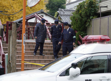 Police officers walk near the scene of the shrine.