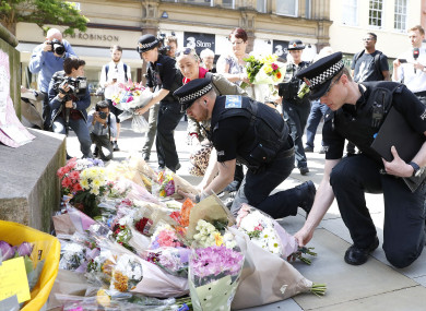 Police laying flowers in St Ann's Square, Manchester, the day after the bombing