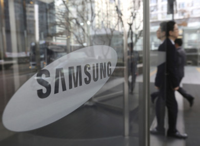 An employee walks past a logo of the Samsung Electronics Co. at its office in Seoul, South Korea.