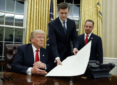 White House staff secretary Rob Porter hands President Donald Trump a confirmation order