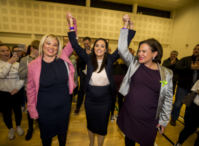 Sinn Fein Stormont leader Michelle O'Neill (left) and Sinn Fein President Mary Lou McDonald raise the arms of Orfhlaith Begley as the newly elected Sinn Fein MP for West Tyrone.