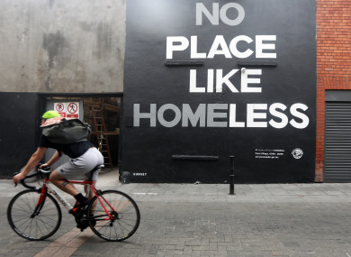 A member of the public passing a mural on Camden Row, Dublin, highlighting homelessness