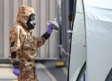 An investigator in a chemical suit removes items as they work behind screens erected in Rollestone Street, Salisbury, Wiltshire.