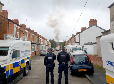 Police keep an eye on the Bloomfield bonfire in Belfast.