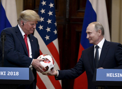 Russian President Vladimir Putin presents a football to US President Donald Trump.