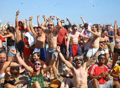 Fans on Brighton beach celebrate England's win over Sweden.