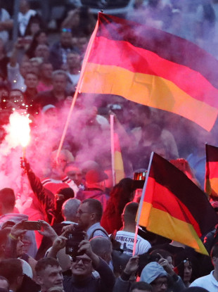 Demonstrators of the right-wing scene ignite pyrotechnics and wave flags of Germany